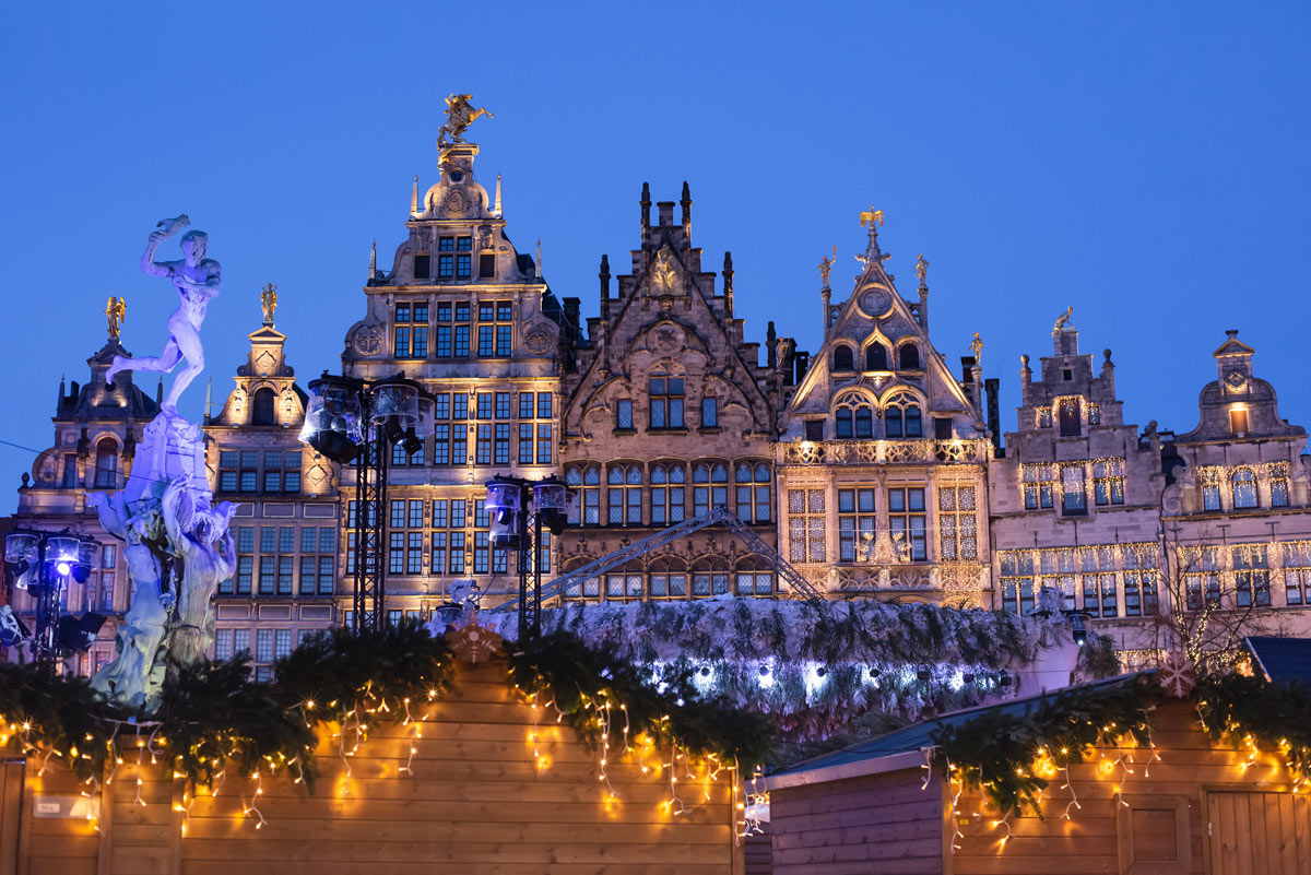 A charming view of the Antwerp Christmas Market in Belgium, with historic buildings adorned with festive decorations and twinkling lights, creating a magical atmosphere for luxury Christmas travel to European Christmas markets.