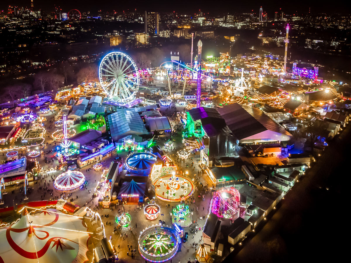 A dazzling aerial view of Winter Wonderland in Hyde Park, London, UK, showcasing sparkling lights and festive attractions, an ideal luxury Christmas travel destination accessible by private jet charter.