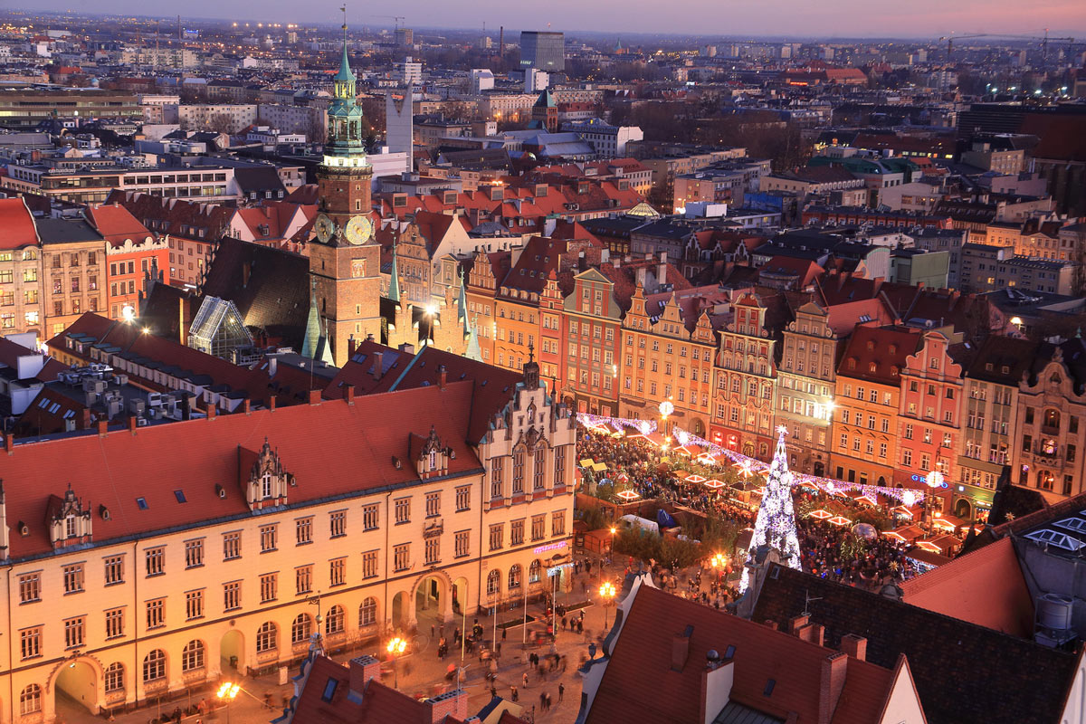 A stunning aerial view of the 9th Krakow Christmas Market in Poland, with festive lights illuminating the market square, offering a unique and luxurious European Christmas market experience.