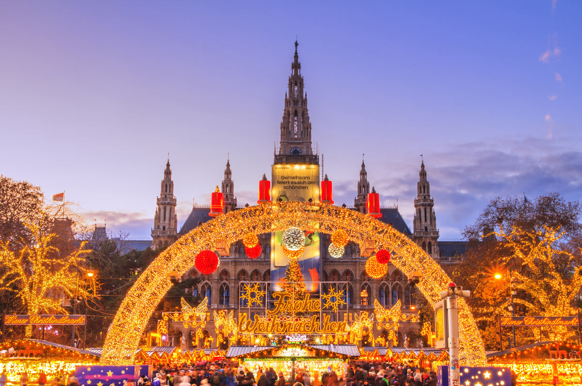 A breathtaking view of the Christmas market in front of the historic Rathaus (Town Hall), adorned with festive lights and beautiful decorations, offering a luxurious European Christmas market experience.