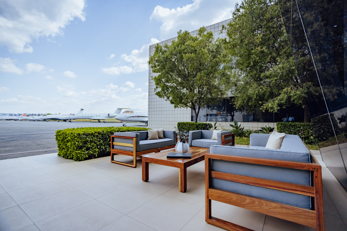 Private lounge overlooking private jets, emphasizing luxury travel and time efficiency for exclusive access to remote African safari destinations.