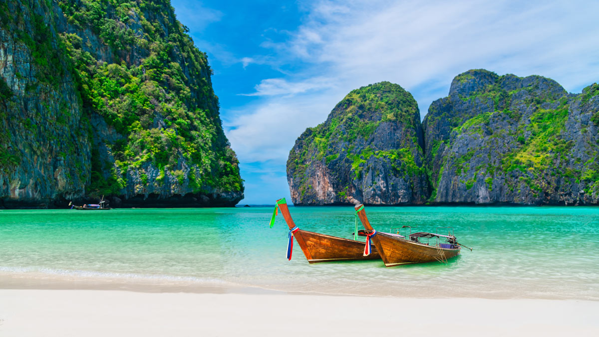 Panoramic view of Maya Bay in Phuket, Thailand, with turquoise waters and boats, offering an exclusive escape for bespoke travel and serene retreats.