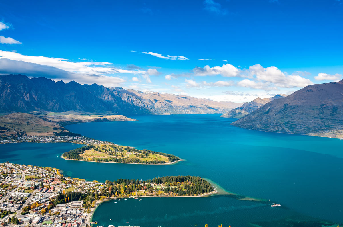 Aerial view of Queenstown's cityscape and Lake Wakatipu on New Zealand's South Island, a haven for luxury escapes and scenic adventures.