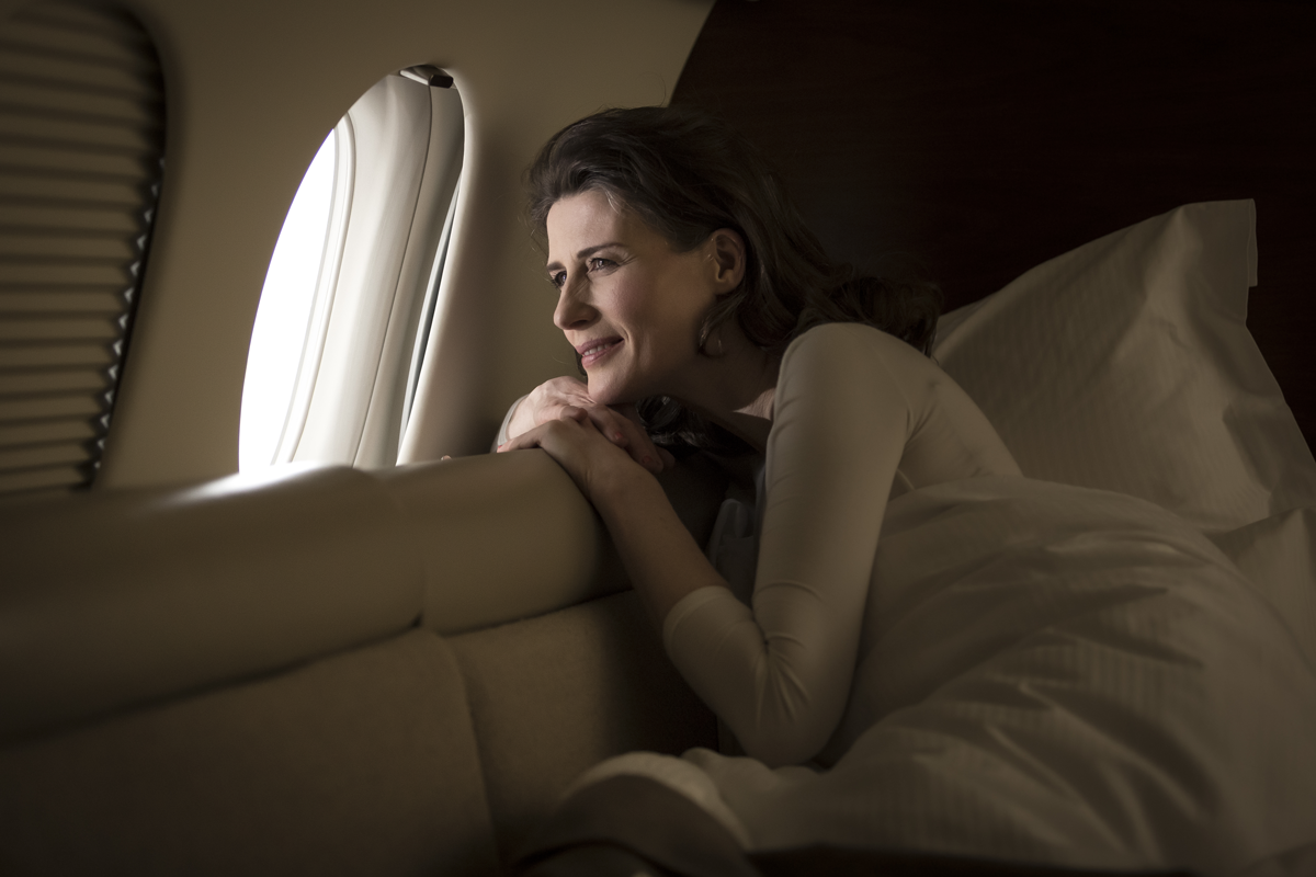 Client wrapped in a soft cashmere blanket, enjoying the privacy and comfort of a private jet, perfect for stress-free luxury travel.