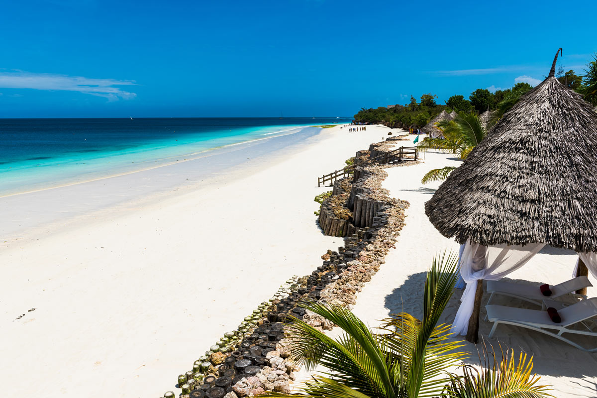 Pristine beach by the blue waters of the Indian Ocean in Zanzibar, Tanzania, offering an idyllic setting for luxury beach escapes and exotic vacations.